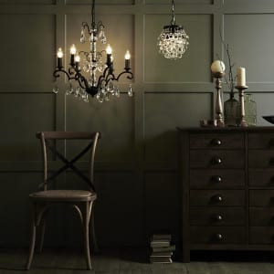 An elegantly lit room adorned with a stunning chandelier, complemented by a sleek dresser.