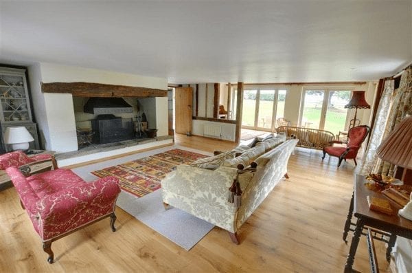 A stylish living room in a UK holiday cottage with wooden floors and a fireplace.