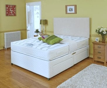 A Double Ortho Backcare Divan Bed in a room with yellow walls and hardwood floors.