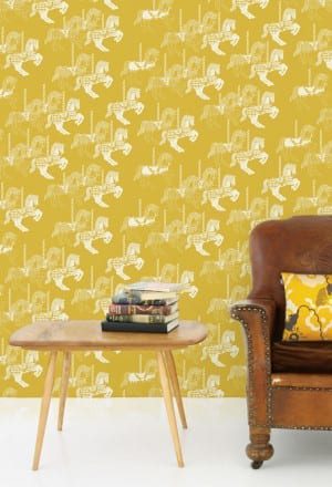 A Mini Moderns yellow wallpaper with a brown leather chair in front of it.