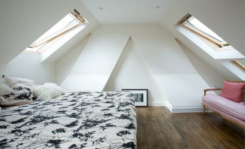 Looking to maximize the value of your bedroom? Check out this amazing space featuring an attic bed and a cozy pink couch.