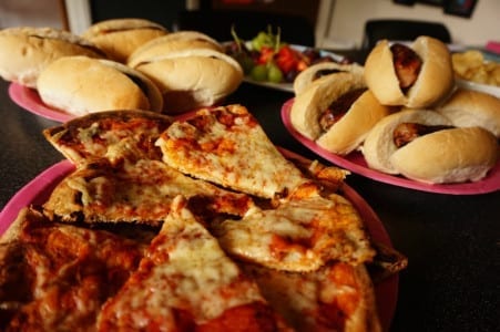 A table full of BBQChallenge pizzas and sandwiches.