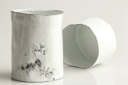 A pair of white ceramic vases with a lustre finish on a white surface.