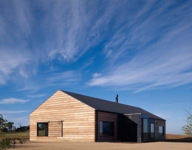 A rustic wooden house sits in the midst of a barren desert, offering a unique and secluded haven for UK expats seeking a top destination to call home.