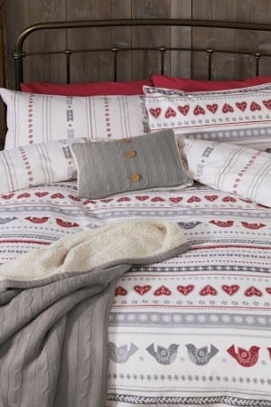 Explore the chic showcase of NEXT Home's new bedding collection featuring stylish blankets and pillows.