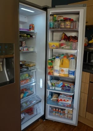 An American Fridge Freezer with its door open and a Food Showcase in a kitchen.