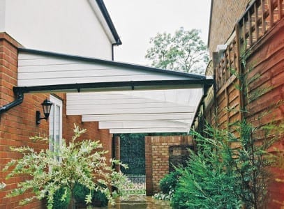 A covered driveway with a white awning over it.