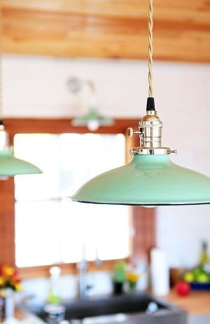 Two pendant lights hanging over a kitchen counter illuminating the cozy home ambiance.