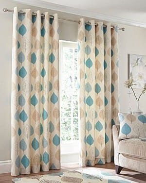 A House of Bath living room with blue and beige curtains, adorned with stylish home accessories.