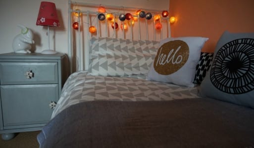 A bedroom makeover with little touches for a tween, including a bed and a bedside table.
