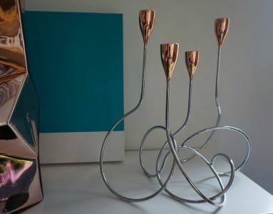 A set of three stylish metal candle holders by Aram, perfect as home accessories on a table.