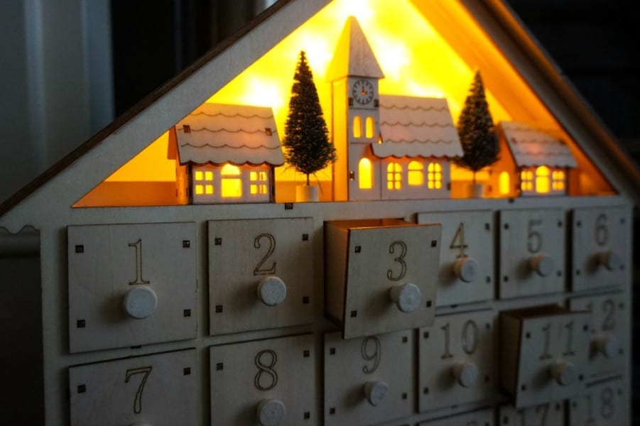 This festive home decor piece for Christmas is a wooden advent calendar adorned with twinkling lights.