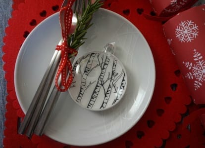 A stylish plate displaying a Christmas ornament on a festive dining table setting.