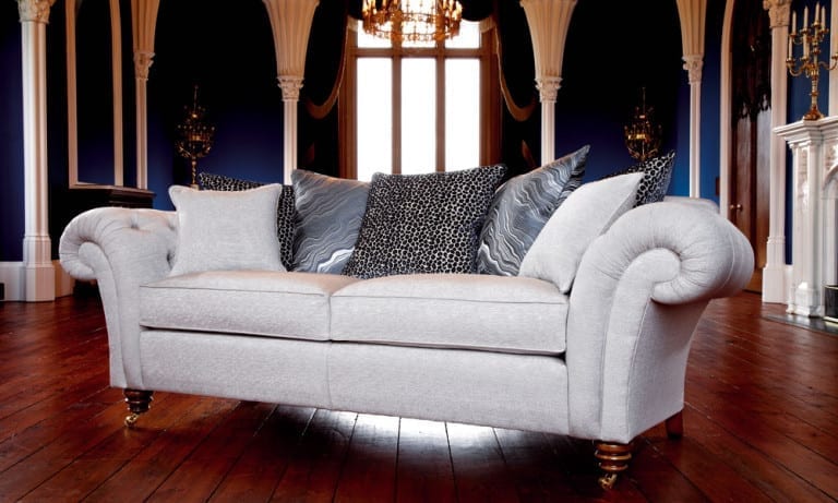 A monochrome white sofa in a stylish living room with blue walls.
