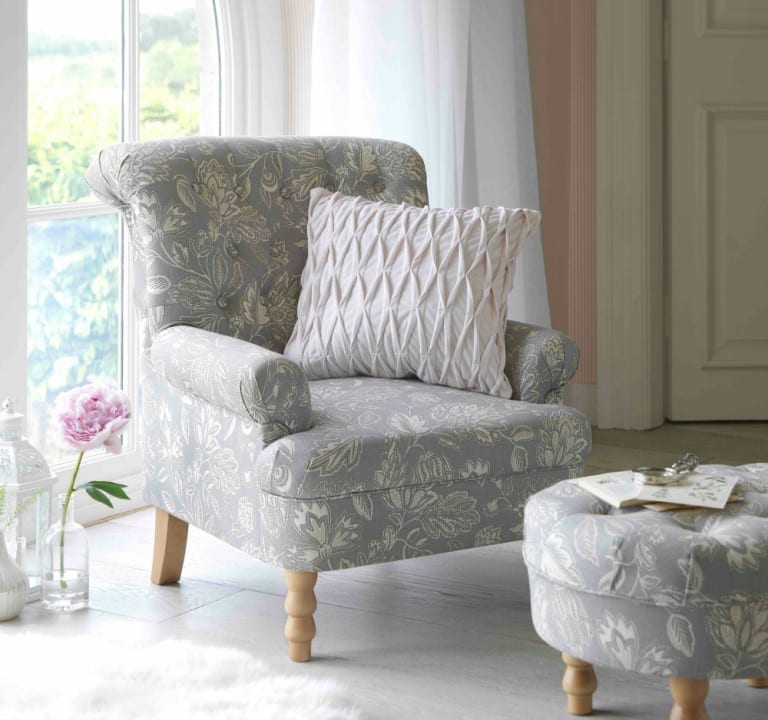 A heart of house chair and ottoman in a room with a window at Argos.