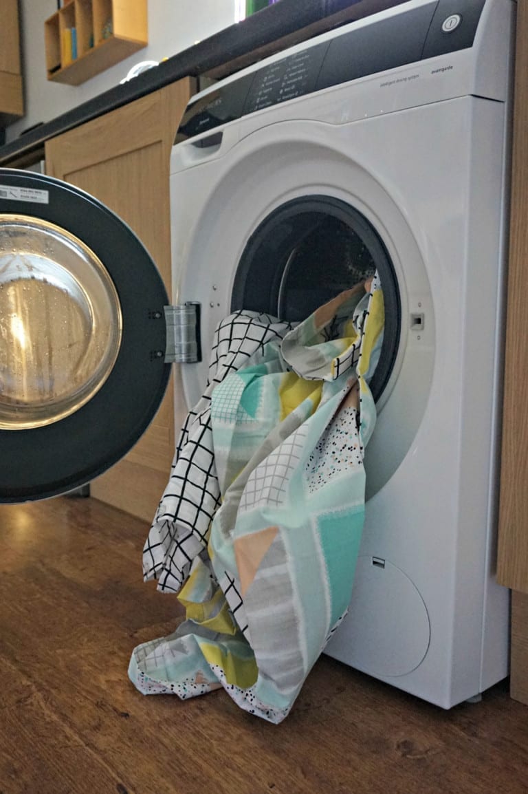 An avantgarde Siemens washing machine with a towel in it.