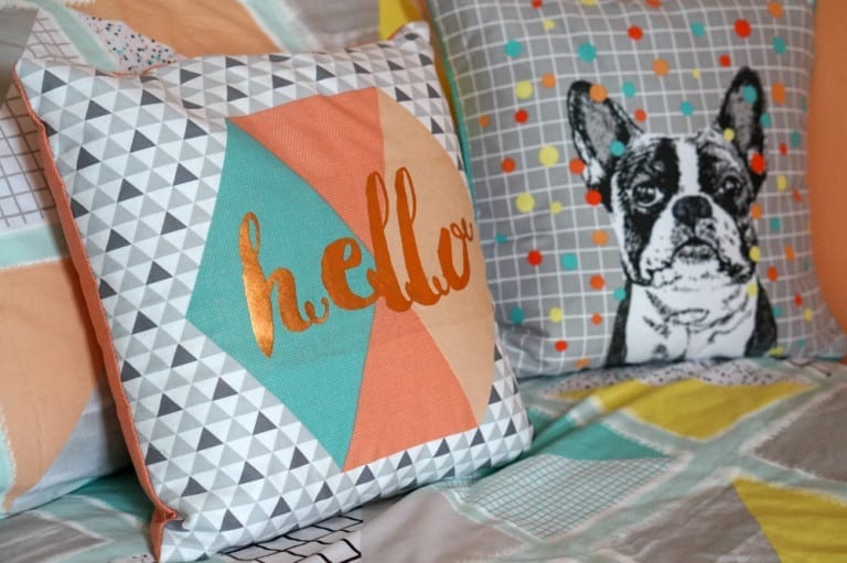 Two pillows with a dog on them on a teen girl's bed.