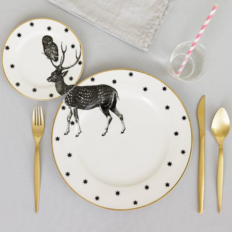 A set of plates with a deer on them that looks perfect for a Christmas table setting.