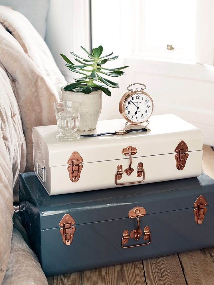 Two suitcases stacked on top of each other, providing bedroom storage solutions on a wooden floor.