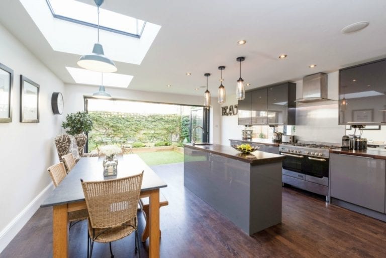 A modern kitchen with a wooden floor and skylights, perfect for staging a home for an easy sale.