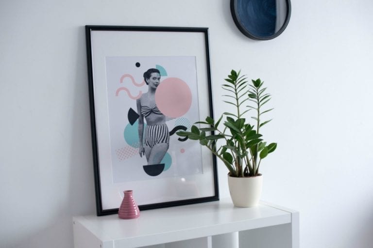 A revamp tip for a bedroom to enhance quality sleep with a picture of a woman on a shelf next to a potted plant.