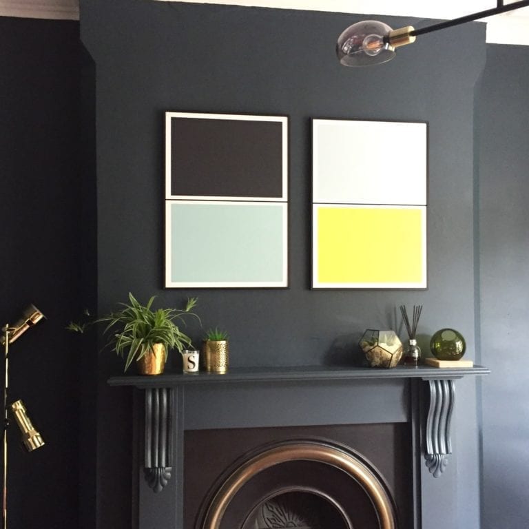 This living room provides home decor inspiration with its elegant black fireplace and tastefully framed pictures.
