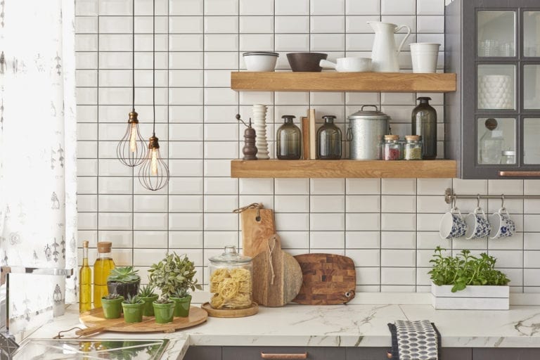 A kitchen with wooden shelves and pots and pans, showcasing the latest TILE TRENDS.