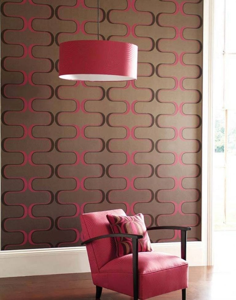 A vintage chair in front of a brown and pink wallpaper.