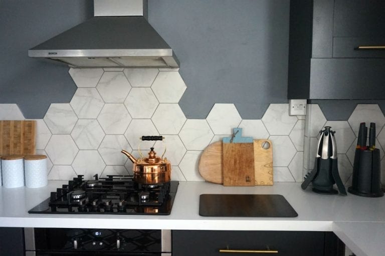 A kitchen with a hexagonal black and white tiled backsplash.
