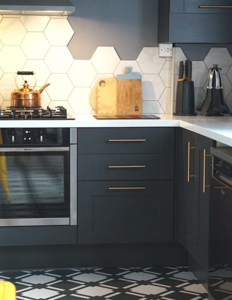An existing kitchen with a black and white tiled floor in need of an update.