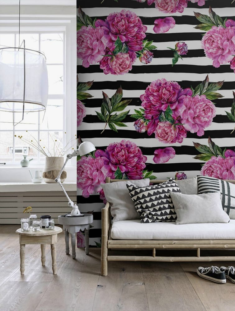 A living room with black and white striped wallpaper, adorned with pink peonies, that will keep your landlord happy in rented homes.