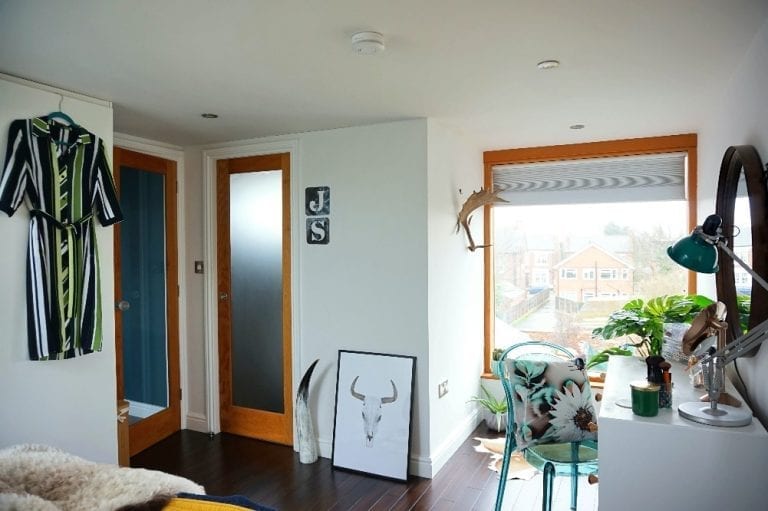 A bedroom with a bed, dresser, and a window.