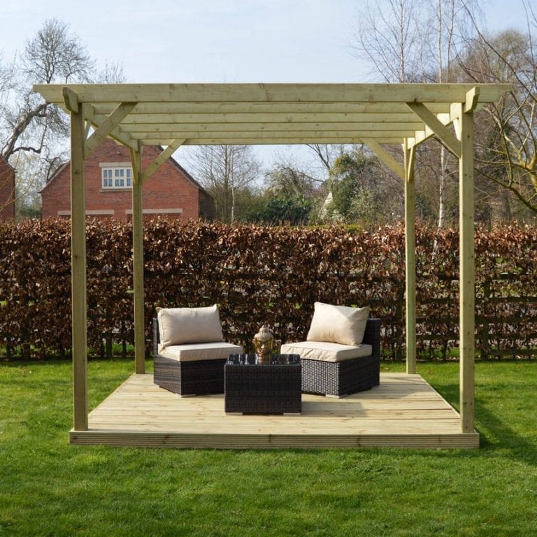 A wooden pergola with wicker furniture in a garden.