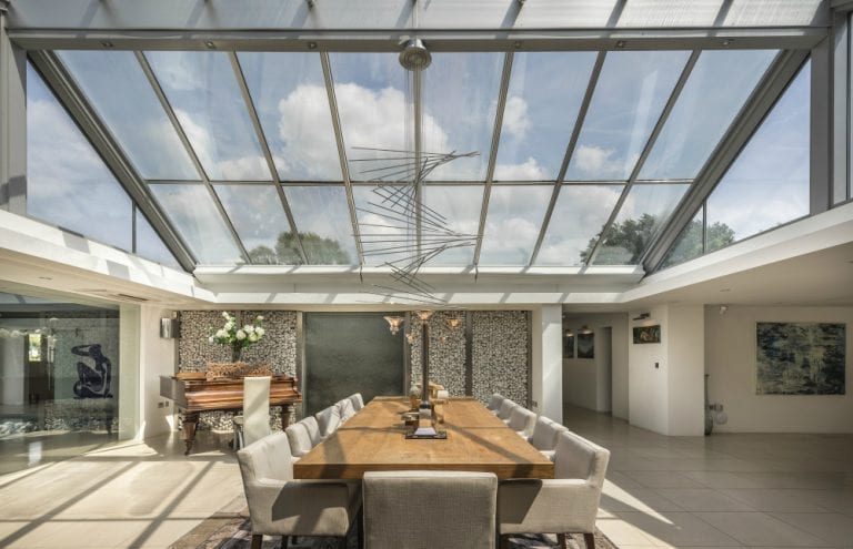 A modern dining room with self-cleaning glass windows and a glass roof.