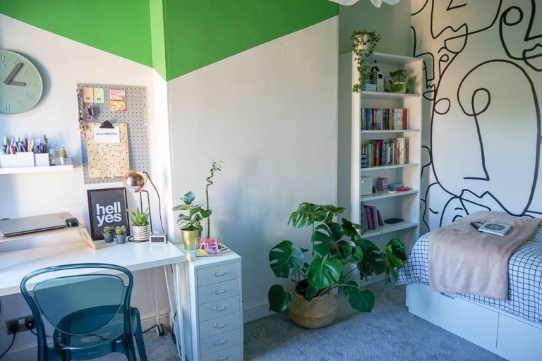A green and white teen girl bedroom with a desk and bookshelf.