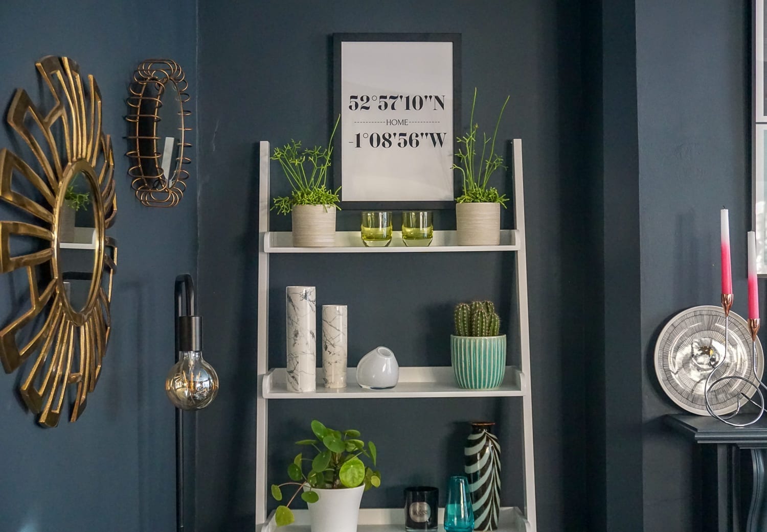 A living room with stylish black walls and a ladder shelf.