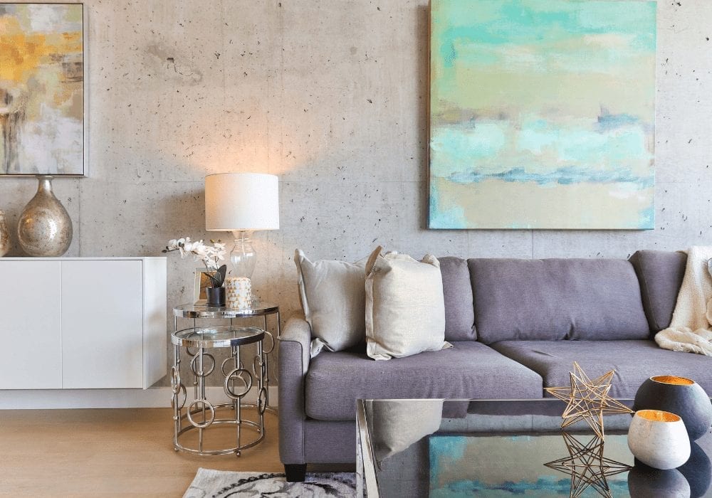 A living room with a grey couch and a coffee table showcasing canvas art.