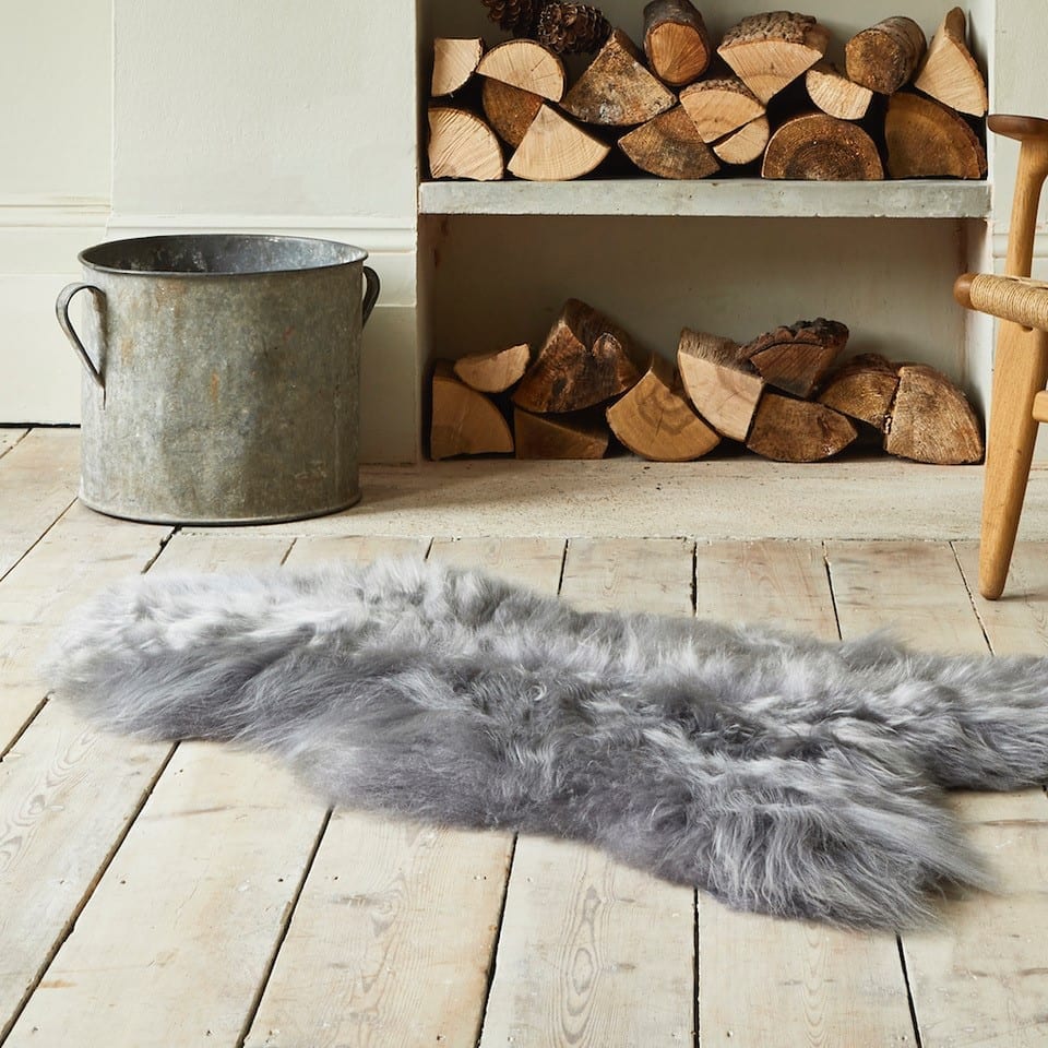 An Icelandic Sheepskin Rug in front of a fireplace at Idyll Home.