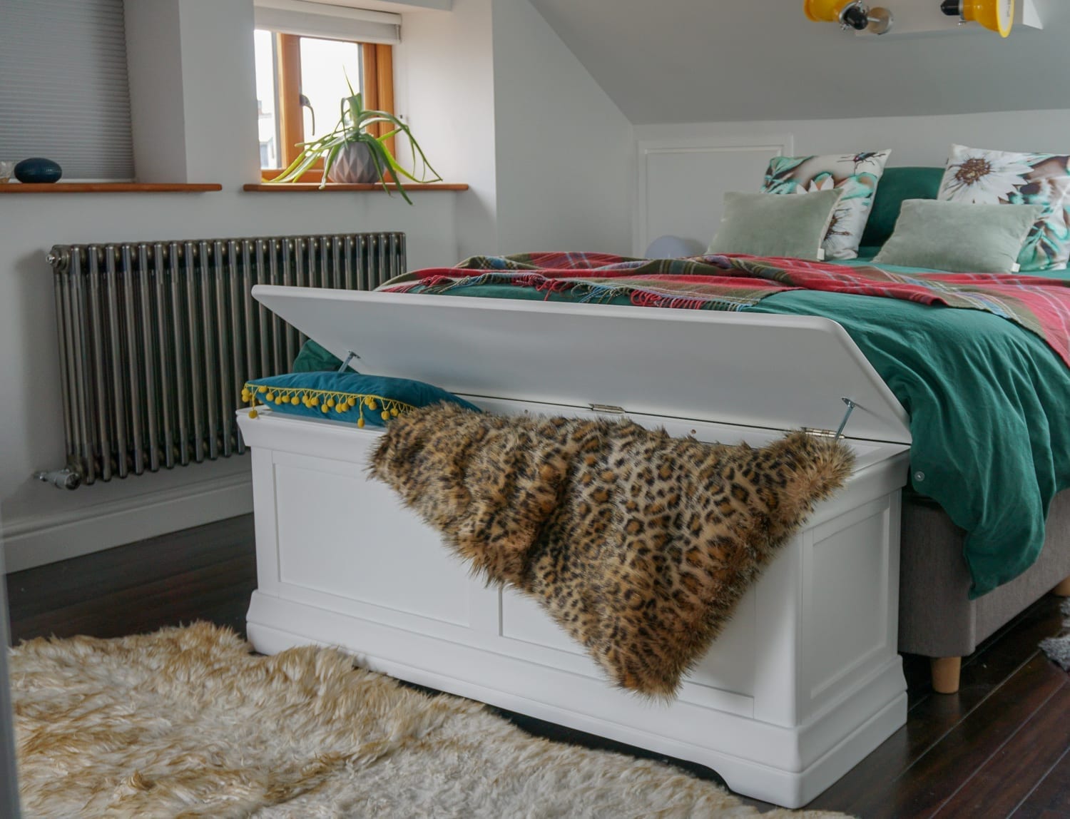 A white dresser in a bedroom with a leopard print accent.