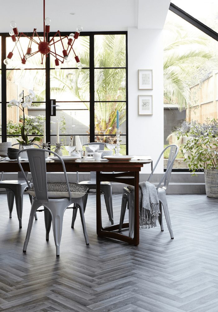 A dining room with a grey herringbone floor, perfect for decorating and entertaining guests.
