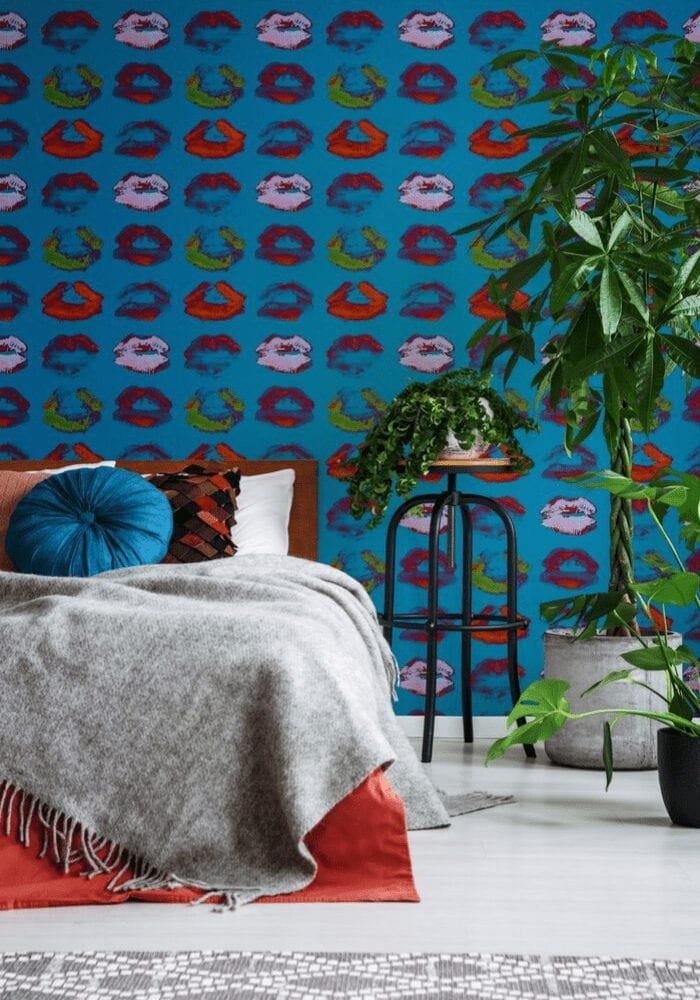 An update to a modern bedroom with colorful wallpaper and a bed.