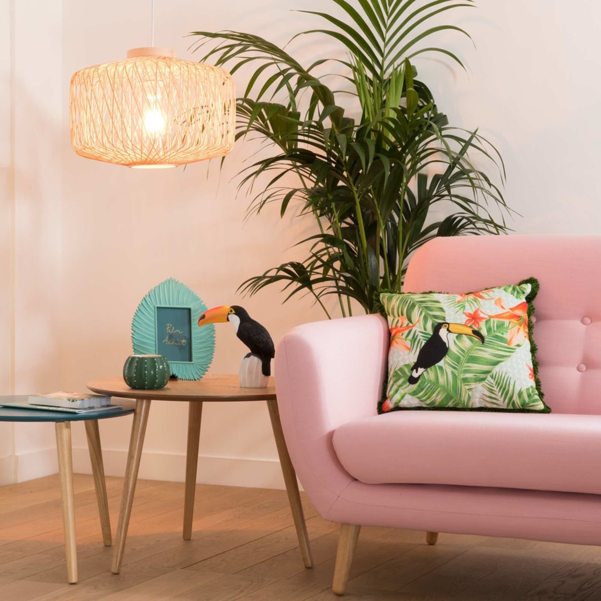 A pink couch with a toucan, adding a playful touch to the living room design.