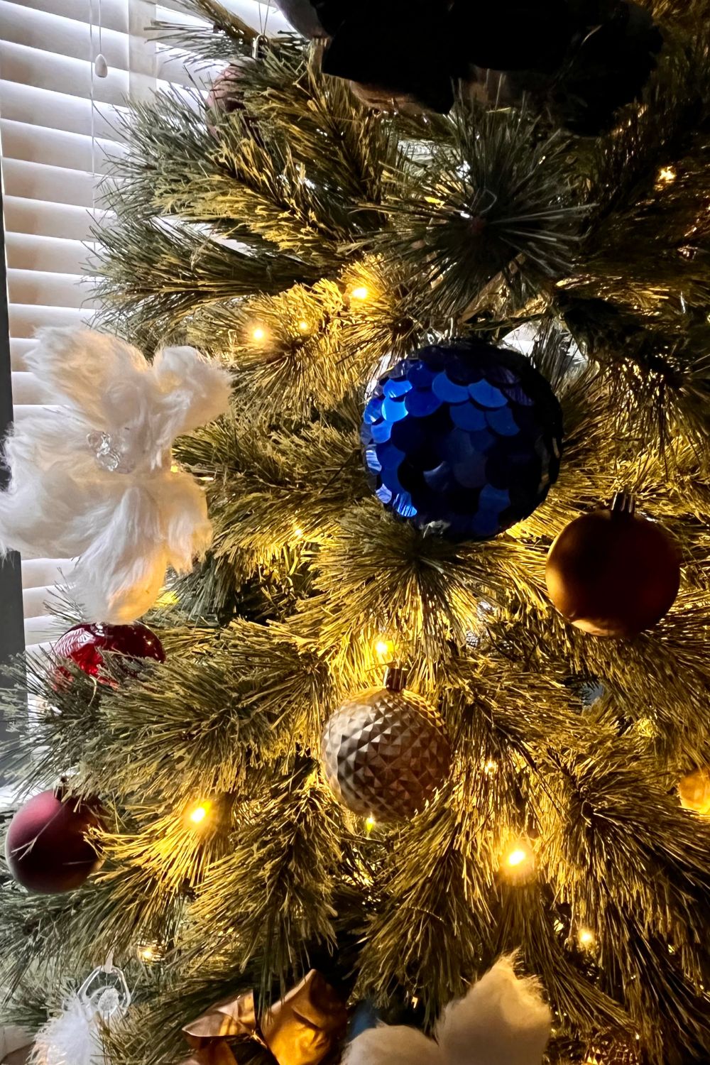 Close up of an elegant christmas tree with gold white and blue ornaments
