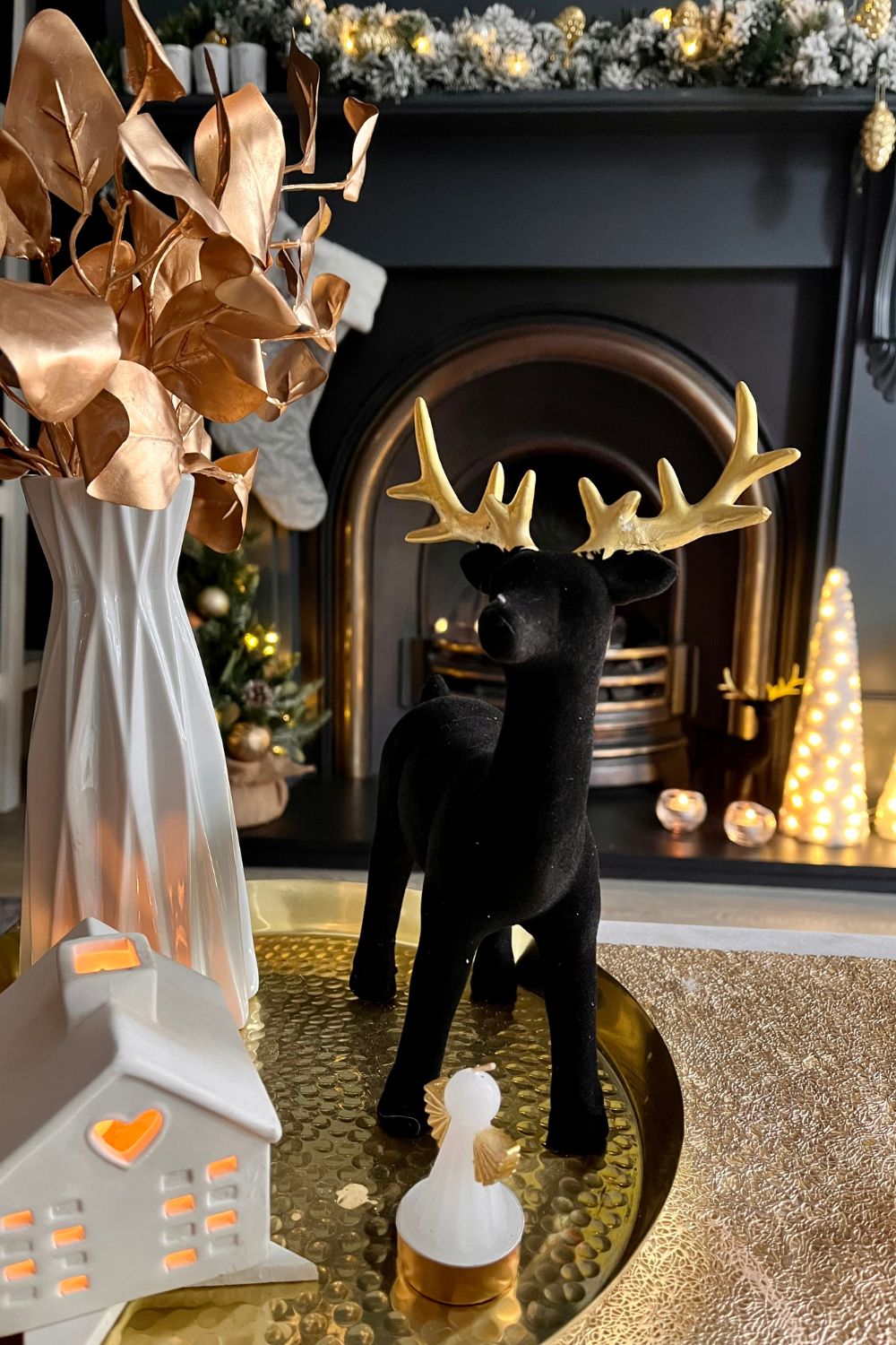 Close up of Christmas table decorations including a black flocked deer
