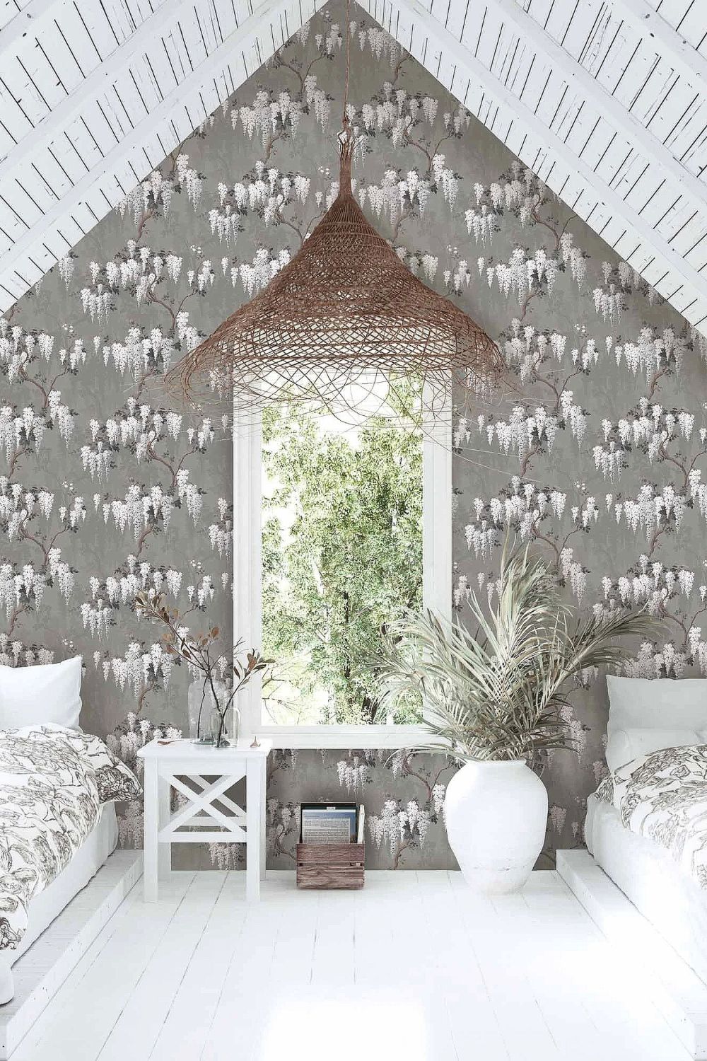 Attic converted into a spare room with wisteria wallpaper, white floors and single beds