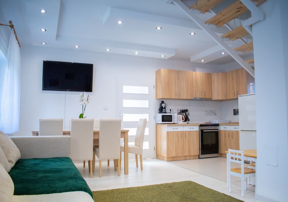 Simple panelled false ceiling design in a white small apartment room with open staircase