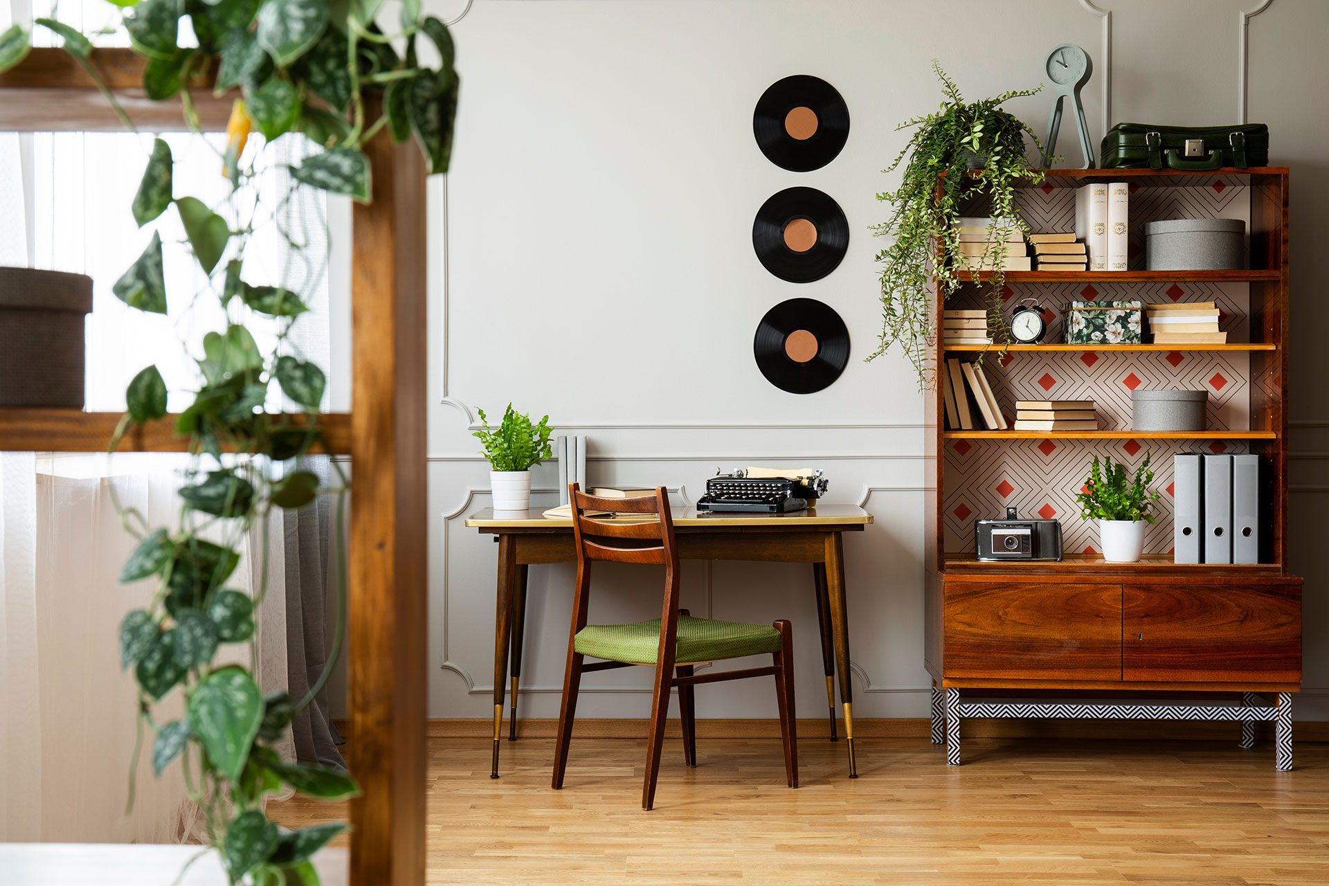 Room decor in a cottagecore house, wooden floor, wooden small table and chair, bookcase and white walls