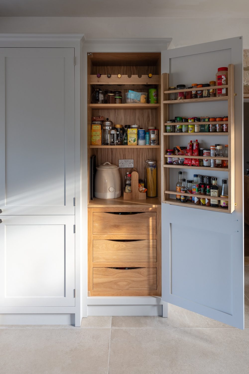 Grey organized kitchen pantry with one door open and one closed