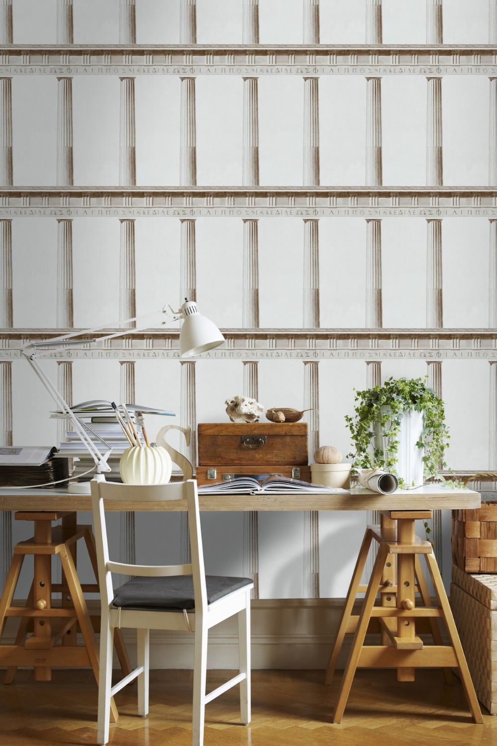 A productive home office with a wooden desk and a white wallpaper.
