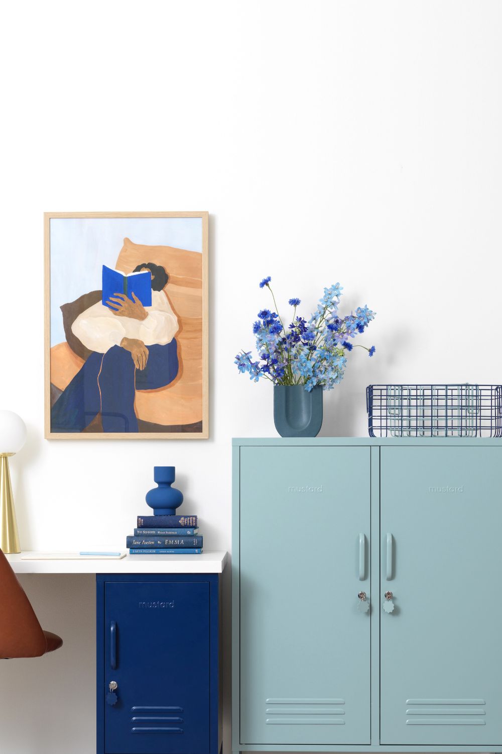 A blue and white home office with a desk and a painting, designed to help you be more productive.